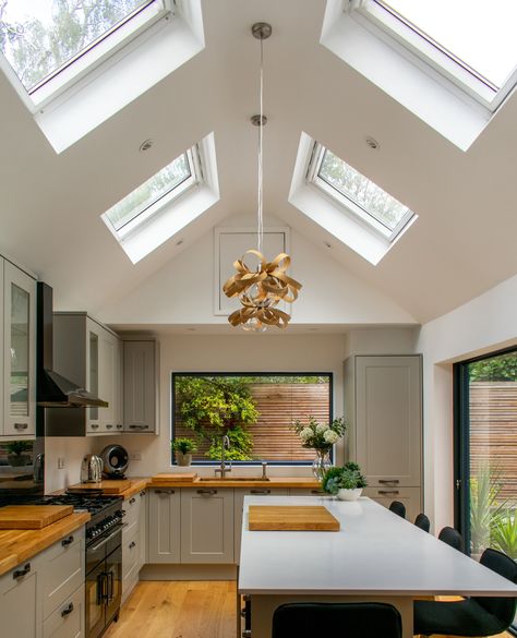 A kitchen so lovely and bright, thanks to the design of the extension and use of glazing!⁠ ⁠ From the roof to the walls, the use of glazing throughout allows an abundance of light to flood in and create a very bright and spacious kitchen! The stunning picture window frames the view from the sink area, with @sunflexuk sliders opening onto the patio. We also installed multiple roof lights in the apex ceiling to add to the open feeling.⁠ Apex Ceiling Kitchen, Gable Roof Windows, Glass Kitchen Extension, Kitchen Skylights, Velux Windows Kitchen, Sliding Doors Internal, Timber Front Door, Velux Windows, Internal Sliding Doors