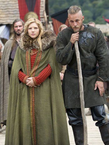 Here Lagertha wears a bilberry-dyed lime green cape and an orange woolen maternity dress. Her husband Ragnar (Travis Fimmel) wears black leather pants and an elaborated molded, decorated black leather vest emblazoned with his insignia -- the raven -- that symbolizes his descent from the great Norse god Odin, also a god of slain warriors and curiosity. Vikings Series, Clothes Dye, Viking Series, Vikings Tv Series, Vikings Tv Show, Vikings Ragnar, Viking Dress, Alexander Ludwig, Bright Outfits