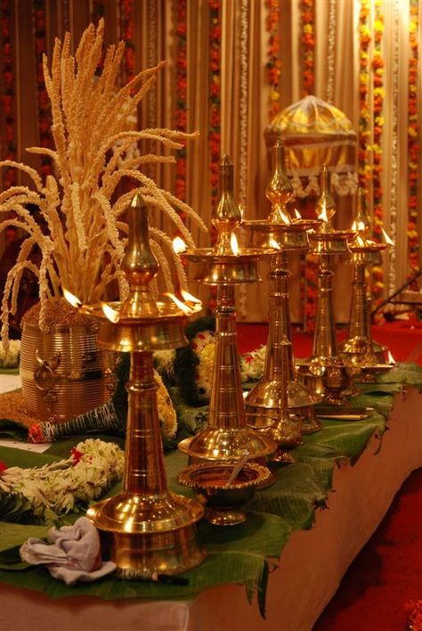 Nilavilakku - A lighted lamp stands for auspiciousness and is considered a welcoming sign. In a traditional Malayali wedding these play an integral role. You line them up in odd numbers (usually 3 or 5) in front of the wedding madapam (alter) and light them with oil and wicks. Kerala Home Decor, Malayalee Wedding, Malayali Wedding, Welcoming Sign, Hindu Wedding Decorations, Kerala Home, Indian Theme, Diwali Decorations At Home, Desi Wedding Decor