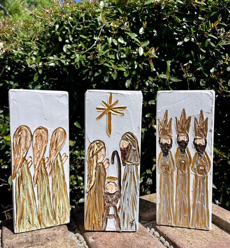 This is a hand painted heavily textured 3 piece nativity scene/manger scene on solid wood blocks.  Each piece is highlighted with metallic gold paint creating beautiful depth.  A great addition to any Christmas decor or to leave out all year to celebrate the birth of Jesus! Approximate dimensions:  9" tall x 3 1/2" wide x 1 1/2" thick Nativity On Canvas, Hand Painted Nativity Scene, Christmas Window Painting Nativity, Painted Christmas Scenes, Painted Wood Blocks Christmas, Wood Block Painting Ideas, Christmas Manger Scenes, Easy Nativity Painting, Nativity Painting On Canvas