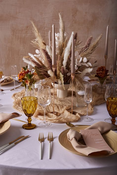 Embrace the popular boho chic trend with this stunning tablesetting. The earth tones of the pampas and dried flowers in the centrepiece are paired well with the beige napkins, taper candles and gold accents. This creates a beautiful neutral look, perfect for birthdays, dinner parties and weddings. 

#TableDecoration #TableSTyling #WeddingInspo #Boho #Weddingtable #WeddingDecor #Partyideas #Dinnerideas #Weddingreception #Bohochic #Earthtones #Floralarrangement #Neutraltones Xmas Table Decorations, Xmas Table, Neutral Christmas Decor, Neutral Christmas, Prop Hire, Table Scape, Table Styling, Boho Christmas, Candle Centerpieces