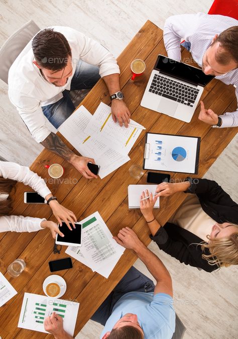 Group of busy business people working in office, top view by Milkosx. Group of busy business people meeting in office, top view of wooden table with mobile phones, laptop, tablet and docu... Office Top View, People Working In Office, Working In Office, Photography Office, Office People, People Working Together, Office Top, Office Team, Technology Photos