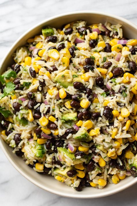 This black bean, corn, and avocado salad with rice is the perfect meatless option for a light summer meal, but it also makes a wonderful side dish! The homemade tangy lime vinaigrette is fresh and delicious. Veggie Side Dishes Summer, Bean Salad Lunch, Light But Filling Dinner Ideas, Black Bean Corn Avocado Salad With Rice, Avocado Side Dish Recipes, Rice With Avocado, Healthy Filling Side Dishes, Dinner Recipes Protein Packed, Corn Rice Salad