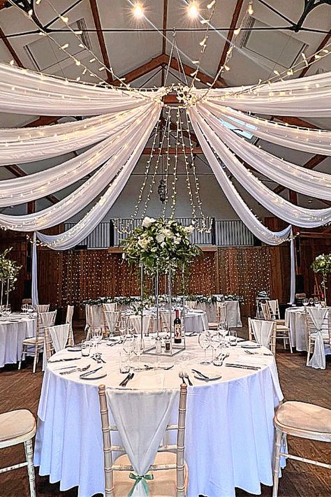 Here’s a stunning draped ceiling and twinkling lights for your big day.#WeddingInspo #CeilingDraping #EventLighting Diy Ceiling Draping Wedding, Ceiling Draping Wedding, Draped Ceiling, Ceiling Fabric, Modern Wedding Theme, Draping Wedding, Ceiling Draping, Reception Backdrop, Wedding Lighting