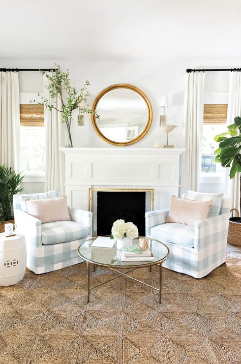 Adjacent to the entry is a sitting room where a Safavieh coffee table joins Ballard Designs’ Classic garden stool on Rush House’s Original rug. The mirror—framed by Visual Comfort’s Hulton sconces—and the fabric on the Lee Industries armchairs are Serena & Lily. Draperies and woven shades from The Shade Store adorn the windows. Serena And Lily Living Room, Modern Coastal Home, The Shade Store, Sunroom Decorating, Shade Store, Florida Style, Rattan Mirror, Serena And Lily, Luxe Interiors