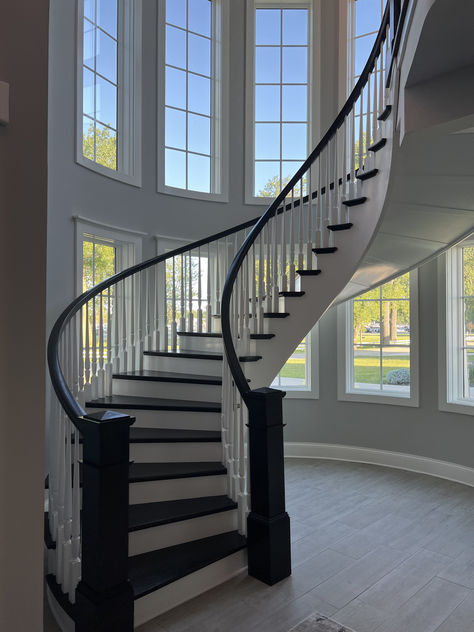 Another finished project! We love how this custom curved staircase turned out! This stairway features many standard wooden stair parts that are both painted and stained. It also has a custom winder treads made to fit the curve of this gorgeous staircase. Interested in a similar style staircase for your home? Follow the link to learn what stair parts were used! Curved Metal Staircase, Floating Curved Staircase, Curvy Staircase, Curved Staircase Ideas, Stairway Railing Ideas, Staircase Curved, Stairway Remodel, Gorgeous Staircase, Unique Staircase