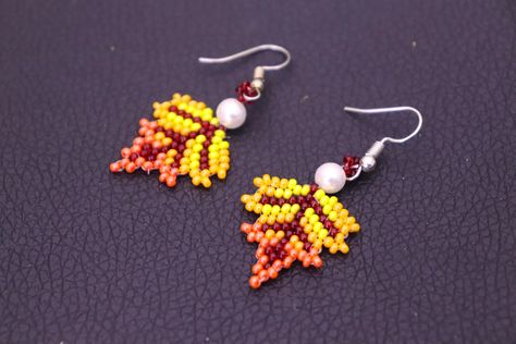 ✍🏻Materials - Marron, yellow, light orange & dark orange seed beads 11/0 -2 pearl beads 6mm - 2 earring hooks - beading thread0.20mm & length 100 cm - needle size# 11 #BeadedEarrings #leafearrings #easyandquickcraft #HandmadeEarrings #EarringDesigns #natureinspiredjewelry #FashionEarrings #JewelryLovers #BeadedJewelry #EarringInspiration #EarringAddict #BeadedAccessories #EarringGoals #UniqueEarrings #JewelryObsessed #BeadedStyle #EarringTrends #EarringEnvy #HandcraftedEarrings #BeadedBeauty Seed Bead Leaf Earrings, Beaded Leaf Earrings, Thanksgiving Beaded Earrings, Fall Seed Bead Earrings, Fall Beaded Earrings, Thread Projects, Fall Bead, Diy Seed Bead Earrings, Natural Inspiration