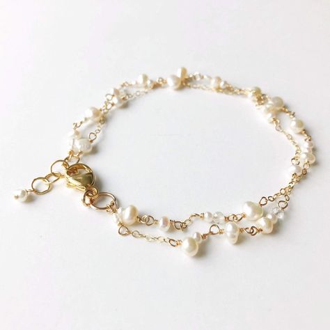 "Poppy Linen Bracelet" is perfect for our pearl lovers out there. Dainty and simple yet makes a beautiful statement. Pair it with a classic Caroline bangle for an elevated look.  - Two strands of dainty white pearls in various shapes and sizes are accented by small chain. Small, faceted crystal quartz add a hint of shi Delicate Gold Bracelet, Hand Jewelry Rings, Pearl Bracelet Gold, Gold Pearl Bracelet, Dainty Gold Bracelet, White Bracelet, Gelang Manik, Jewellery Sketches, White Bracelets