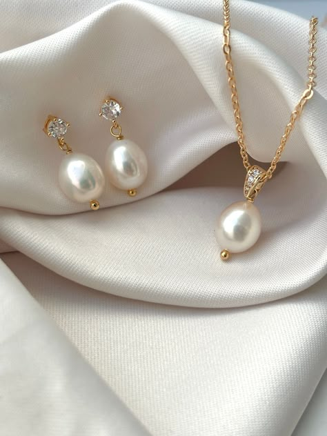 If you are looking for a subtle sparkle to light the classic pearls, this set is for you.  These pieces are designed with the perfect balance of dainty cubic zirconias and oval freshwater pearl drop. Perfect for brides looking for a  jewellery set that is timeless.  PRODUCT DETAILS: -Real oval freshwater pearls  -High quality and lightweight. -handmade to order in order in our UK studio -The gold-filled materials used make it a high quality and waterproof product great for daily use or for a spe Wedding Necklaces For Bride Pearl, Dainty Pearl Jewelry, Simple Gold Pearl Jewelry, Pearl Sets Jewellery, Bride Jewellery Gold, Pearl And Gold Jewelry, Diamond And Pearl Necklace, Pearl Bridal Jewelry Sets, Bridal Pearl Jewelry