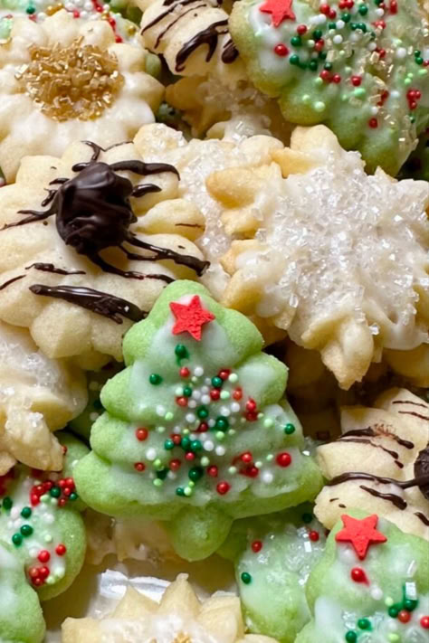 A plate of Spritz Christmas cookies. Cookie Spritz Recipes, How To Make Spritz Cookies, Pressed Cookies Christmas, Small Batch Spritz Cookies, Glazed Spritz Cookies, Recipe For Cookie Press Cookies, Icing For Spritz Cookies, Dairy Free Spritz Cookies, Jello Spritz Cookies