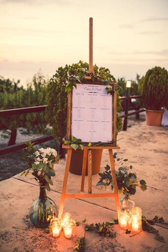 Seating plan displayed with a natural wooden frame on a rustic wooden easel, decorated with foliage, Mallorcan vases with loose flowers and cylindrical vases with chunky candles.  Terrace at Son Marroig, at the entrance to the dinner area. Natural Wedding Flowers, Mallorca Wedding, Photo Corner, Wedding Mirror, Wood Easel, Artist Easel, Wooden Easel, Wedding Entrance, Art Easel