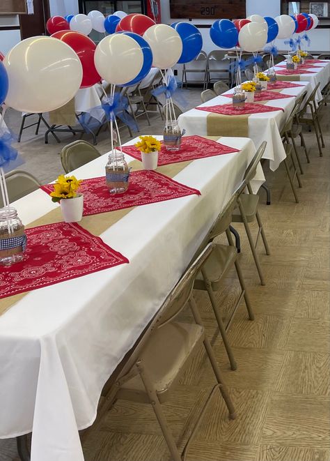 White table cloths, red bandanas, balloons on sticks tied together with blue tulle, mason jars with blue checkered ribbon, burlap table runner, sunflowers in white pots. Western Table Decorations, Balloons On Sticks, Country Graduation, Western Party Decorations, Cowboy Themed Birthday Party, Western Table, White Pots, Cowboy Theme Party, Western Birthday Party