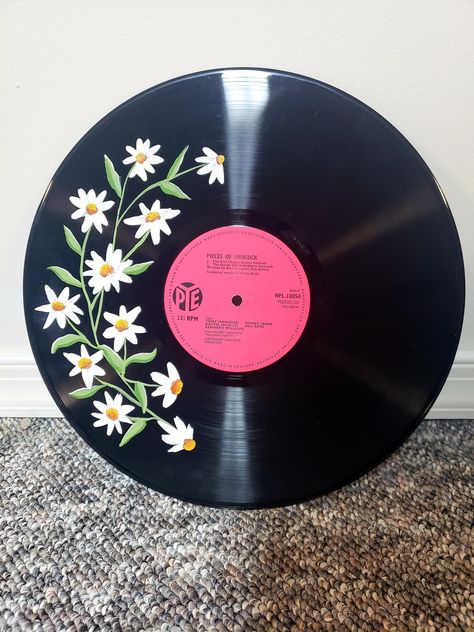 Daisies painted on upcycled vinyl  Since I am reusing old damaged vinyls, each order is unique. each order will have a different record than pictured. If you would like the center to be a particular color message me and I can let you know what I have available. This is intended for decoration purpose and not meant to be played. Vinyls sourced locally. Record Ideas Wall Art, Flower Vinyl Painting, Flower Painted Records, Painted Vynil Records Aesthetic, Vinyl Art Paint Aesthetic, Painted Cds On Wall, Painting Records Vinyl, Painting Ideas On Cds, Things To Paint On Cds