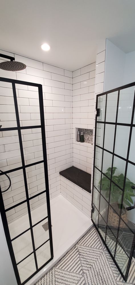 The French door-inspired DreamLine Unidoor Toulon shower door looks incredible in this modern bathroom built by the talented pros at @garrettrenovations! It coordinates perfectly with glossy white subway tile and matte black fixtures. The Unidoor Toulon features 3/8-inch-thick tempered glass, an industrial grid pattern made from our JetGlaze paint technology, and our ClearMax water repellant and stain resistant coating for superior protection. Make it yours! Check out website to get started! Tiled Shower With Black Fixtures, Glass Shower Frameless, Glass Bathroom Shower Ideas, Black Paned Shower Door, Bathroom Remodel Industrial, Drop In Shower Ideas, Shower Tile With Black Fixtures, Black And White Bathroom Ideas With Tub, Black Trim Shower Door