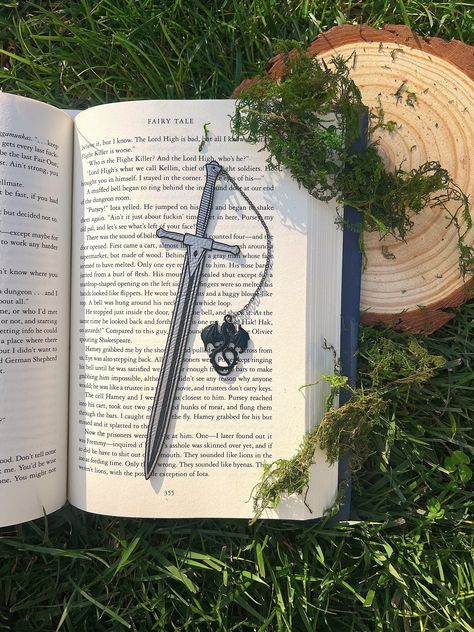 Leather Sword Bookmark, Fantasy Bookmark, Elven-Inspired Bookmark, Gift for Readers, Elf Fairy Faerie Fae Bookmark Make your reading a little extra magical with this beautiful engraved faux leather bookmark with a metal dragon tassel. This bookmark is engraved in my home workshop on faux leather leatherette that engraves into a light silver color and finished with a metal dragon charm. HANDCRAFTED IN THE USA- Made in Los Angeles, California by a small, family-owned business NATURAL VARIATION DIS Faux Leather Bookmark, Wire Bookmarks, Fantasy Bookmarks, Dragon Bookmark, Metal Dragon, Bookmark Design, Elf Fairy, Charm Bookmark, Pretty Knives