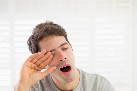 Sleepy young man yawning as he rubs his eye in bed at home Sleepy Man, Tired Person, Always Sleepy, Body Stretch, Quiet Moments, Pose Reference Photo, Editorial Illustration, Good Sleep, Explore The World