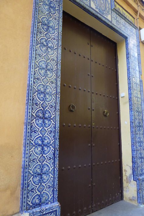 Nice double wooden door surround by tiles in Seville, Spain. Tile Around Door Frame, Royal Doors, Tile Colors, Entrance Ways, Moroccan Tiles, Seville Spain, Secret Rooms, Spanish House, Daily Living