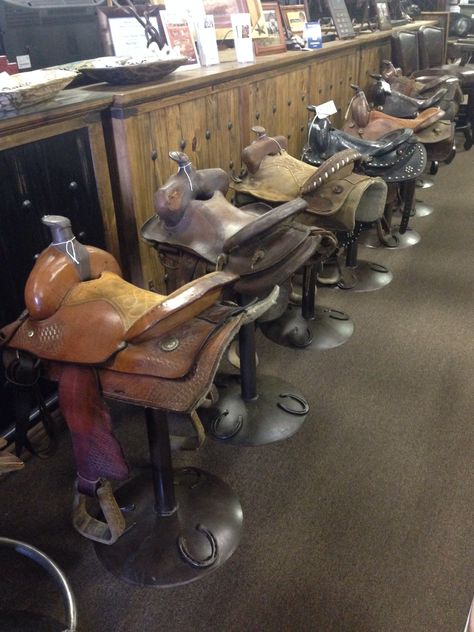 How awesome saddle bar stools so cute Saddle Barstools In Kitchen, Saddle Stools Diy, Horse Saddle Stool, Saddle Chair Stools, Saddle Bar Stools Diy, Saddle Repurpose Ideas, Old Saddle Decor Ideas, Saddle Barstools, Saddle Display