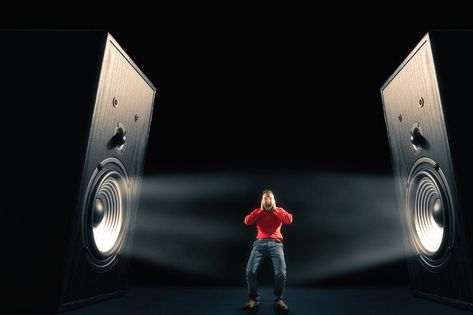 The man cover his ears from loud noise wafting out from big sound speakers with funny faces. On black background. Image. Noise Drawing, Big Speakers, Loud Speaker, Sound Speaker, Wet Floor, Loud Noises, Creative Ads, Funny Faces, Cover Art