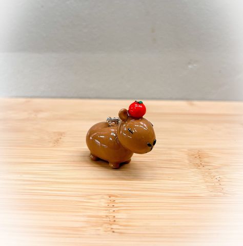 "Capybara with Apple keychain  This keychain is made from polymer clay and varnished with resin for extra durability and shine. However, please keep in mind that it is handmade so gentle use is still recommended. There may be imperfections due to the nature of it being handmade.  Dimensions: Length: approx 1.5\"  Height: approx 1.25\" I am still new to the world of polymer clay and I am learning every day. Any feedback regarding my products is greatly appreciated. Thank you!" Polymer Clay Capybara, Capybara Clay Art, Clay Capybara, Capybara Keychain, Apple Keychain, Aesthetic Minecraft, Animal Keychain, I Am Learning, Chino Hills