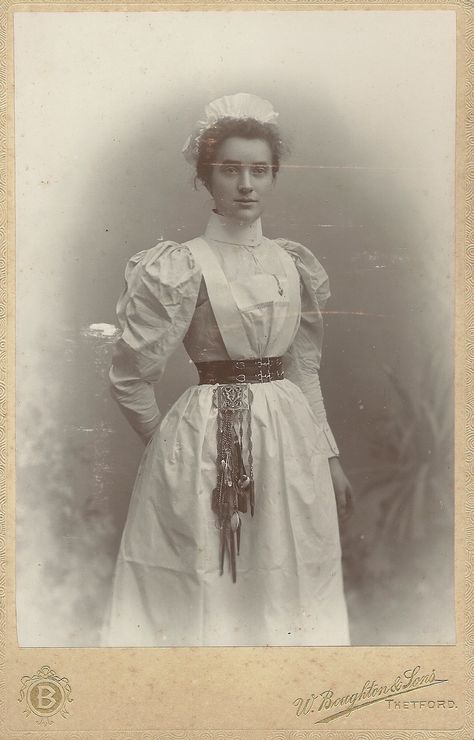 https://flic.kr/p/SxF6rR | Unidentified Nurse,Thetford Cabinet Card | the  Chatelaine attached to her belt looks to be so heavy that she needs a reinforced belt! Chatelaine Belt, Victorian Doctor, Nurse Aesthetic, Doctor Outfit, Vintage Nurse, Mode Costume, Dress History, Uniform Dress, 19th Century Fashion