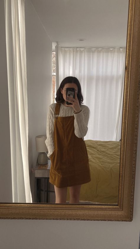 Overalls dress fall sweater outfit cream neutral aesthetic yellow cute trendy modest Overall Dress With Sweater, Outfits With Overall Dress, Orange Overall Dress Outfit, Overalls Dress Outfit Fall, Dress With Sweater Underneath, Brown Overall Dress Outfit, Autumn Overalls Outfit, Bakery Aesthetic Outfit, Modest Fall Aesthetic