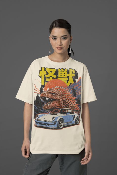 We are introducing our vintage-inspired Godzilla-like Kaiju monster and  Porsche Japanese graphic tee! This tee is a true homage to the golden era of Japanese cinema and automotive art, featuring a stylish design that merges the iconic Godzilla-like monster with a cool vintage car graphic. Crafted with utmost attention to detail, this tee offers exceptional comfort and durability, making it perfect for everyday wear. * Processing and Shipping Times - Please allow 3-5 business days for your order to be processed and made - Standard shipping takes 3-5 days - Please make sure your shipping address is correct before placing an order - Printed and Shipped in the USA * Returns & Exchanges - All sales are final unless the item arrives damaged - Please make sure to order the correct size, as we ca Japanese Graphic Tee, Vintage Car Graphic, Godzilla Kaiju, Japanese Cinema, Porsche Vintage, Japanese Graphic, Fade Designs, Retro Graphic Tees, Automotive Art