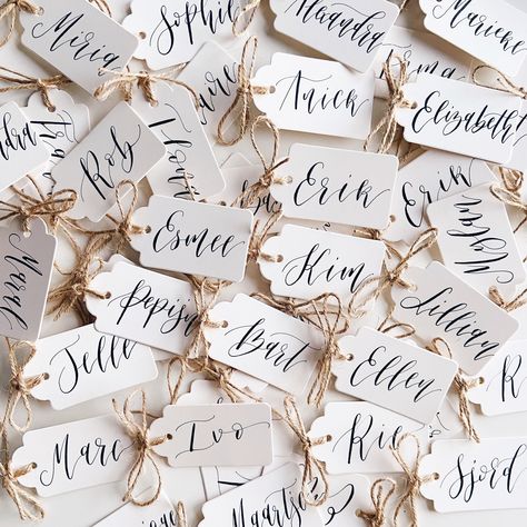 Set of 5 calligraphy gift tags to use as place cards, wedding favours or add to your gifts. These are hand lettered individually with a calligraphy pen and ink. After the purchase, please add a note or send me a message with all the names. Each tag comes with a kraft twine tied in a bow, ready to be attached to your gifts. These are 4x7cm in size. The price shown is for 5 tags. The turnaround is usually 1-4 days, depending on the quantity. Calligraphy Place Setting, Calligraphy Name Tags, Cricut Wedding Name Place Cards, Name Places For Wedding, Wedding Name Tags Ideas, Cricut Name Tags, Wedding Name Place Ideas, Name Tags Wedding Table, Name Tags Ideas