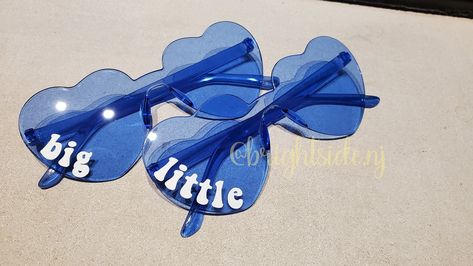 "This listing is for 3 pairs of heart shaped glasses!  This is a set of 3! One says big one says little and one says middle!  These are perfect for sorority, cheer or dance big little reveals! Text is in white and will go on the right \"eye\" Personalization is done is premium vinyl. Message me for more color options." Big Little Hint Ideas, Big Sis Lil Sis Gifts, Cheer Team Gift, Big Lil Gifts, Big Little Sorority Shirts, Big/little Baskets, Little Gifts Sorority, Big Little Canvas, Cheer Team Gifts