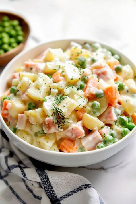 If you've never had Olivier salad before, you're in for a treat! This Russian delicacy is packed with carrots, potatoes, peas, ham, and pickles in a delectable dressing. Russian Potato Salad, Olivier Salad, Thanksgiving Brunch, Carrots Potatoes, Peas And Carrots, Pea Salad, How To Cook Ham, Diced Potatoes, Carrot Salad