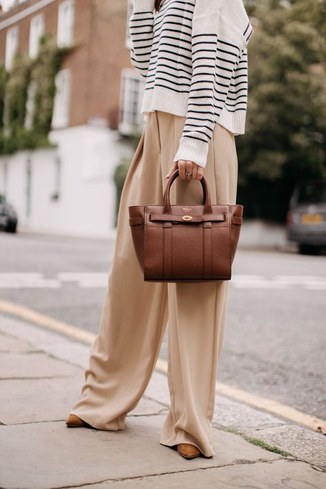 I’ve always loved wide leg trousers. And as of lately, they’ve become what is considered a “trend.” So today, I’m sharing a trend to try – wide leg trousers. Plus ways you can style them. Tan Trousers Outfit, Tommy Hilfiger Outfits, Hilfiger Outfits, Outfits Beige, Alyson Haley, Tan Trousers, Tan Legs, Living In London, Trouser Outfit