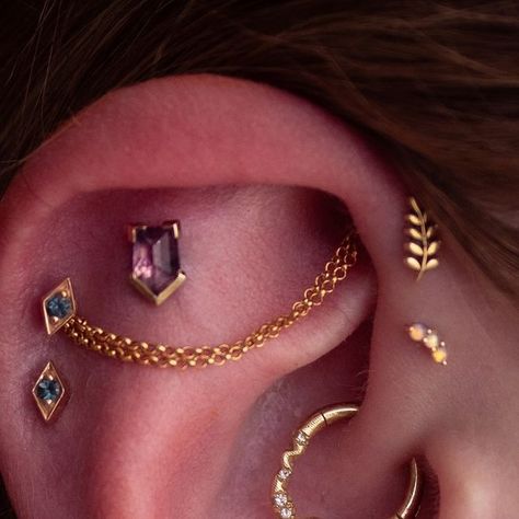 Aileen Fritz on Instagram: "Ear styling from Saturday! The inspo photos that Jenny sent me for her ears, were so colorful that I knew I had to do bold pops of but and purple throughout this whole setup.  @mettleandsilver  have been putting out  some amazing sapphire ends from a specific mine in Tanzania. I had to use their Winza Sapphire as the center of this whole setup.  I added some @hialeahfinejewelry charms to an earlobe orbital while make use of some custom @modernmoodbodyjewelry London topaz Iris ends in the helix. @mayajewelry Grow in the forward helix & Either Way with diamonds from  @pupil.hall  im the daith." Different Helix Piercings, Forward Helix And Helix Piercing, Daith Forward Helix Piercing, Forward Helix Piercing Ideas, Vertical Helix Piercing, Ear Setup, Pupil Hall, Triple Forward Helix Piercing, Ear Styling