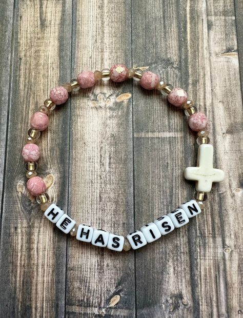 Matthew 28:5-6 says He Has Risen. Little word letter beads spell this out and adorned with a stone cross surrounded by pink Czech glass beads. Tiny glass crystal beads add a hint of sparkle.  Bracelets are available in a variety of lengths.  Pick your custom length from the drop down menu below.  Please be aware that beading may slightly differ from what is pictured as to accommodate selected sizing.  All our bracelets are made with quality in mind.  With that being said, all bracelets should be Christian Pony Bead Bracelets, Words Bracelets Beads, Christian Bracelets Women, He Is Risen Bracelet, Diy Cross Bracelets, Beaded Cross Bracelet, Bracelet Ideas Christian, Christian Clay Bead Bracelet Ideas, Cross Beaded Bracelet