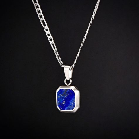 The Lapis Lazuli pendant. Created using real cuts of a Lapis Lazuli stone. Every stone is unique making it the perfect necklace for your unique style. A Silver Pendant finished with a polished Royal Blue Stone - a classy addition to our Pendant Collection. Also available in 18K Gold. DETAILS Pendant size: 1.5cm x 1.5cm Chain styles: Figaro (3mm), Rope (2.5mm) Materials: Stainless Steel / 18K Gold PVD Plating / Lapis Lazuli Necklace clasp: Lobster Lifetime Warranty Packaging: Packed in a Twistedp Blue Stone Pendant, Mens Necklace Pendant, Lapis Pendant, Lapis Lazuli Pendant, Lapis Lazuli Necklace, Mens Silver Necklace, Necklace Clasps, Lapis Lazuli Stone, Stone Pendant Necklace