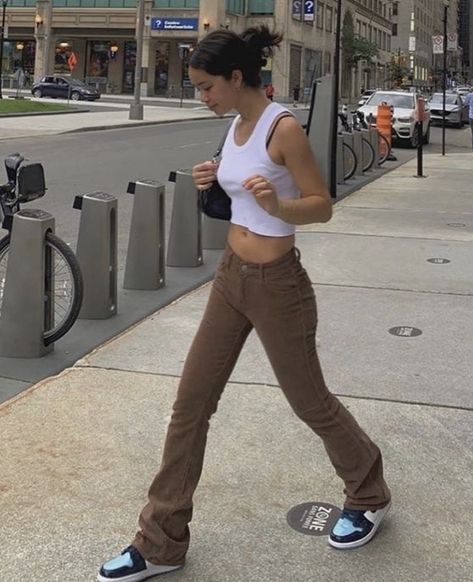 white cropped tank top paired with low waisted brown jeans, a black shoulder bag or baguette purse, and air jordan 1 retros unc patent leather, pinned up hairstyle #hair #hairstyles #purse #brown #outfits #outfitideas #fashion #sneakers #jeans #cropped Mode Dope, Bekväma Outfits, Vestiti Edgy, Looks Pinterest, Brown Jeans, Populaire Outfits, Brown Outfit, Looks Street Style, Modieuze Outfits