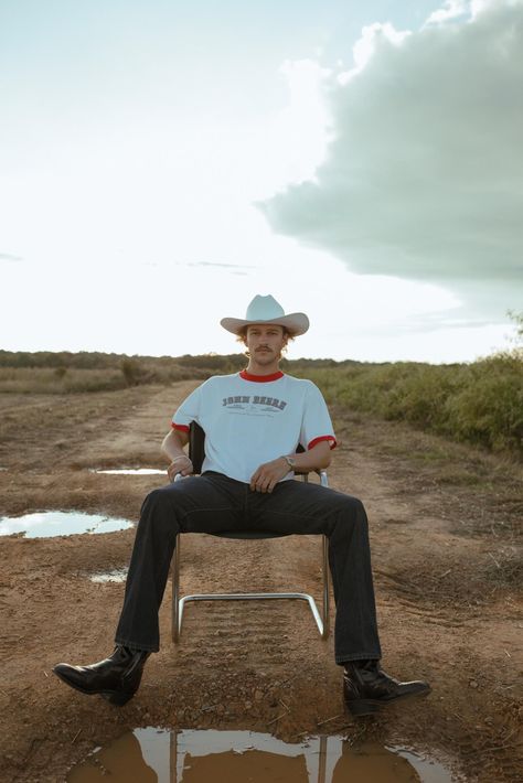 Cowboy-sitting-in-chair-in-front-of-puddle Cowboy Men Outfit, Cowboy Editorial, Hipster Cowboy, Cowboy Outfit Men, Mens Cowboy Boots Outfit, Urban Cowboy Style, Cowboy Men, Mens Western Wear, Modern Cowboy