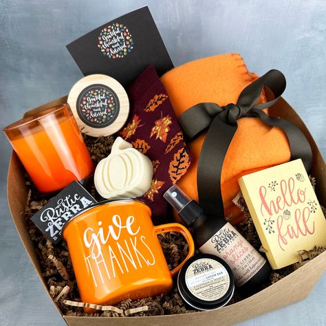 My gift boxes make the perfect gift! Each box measures 10"x10"x6", is tied with orangewhite bakers twine and is ready to give as a gift to that special person. Gift box includes: (1) 7 oz natural, hand poured, soy candle in orange jar with wooden lid in your choice of scent (1) custom box of matches (1) pair of fall socks (1) 50"x60" orange fleece blanket (1) small fall wooden sign (1) 2 oz orange slices linen spray (1) small pumpkin pie lotion bar (1) fall 12 oz coffee mug (1) pumpkin shaped go Fall Gift Box Ideas, Small Pumpkin Pie, Fall Gift Basket Ideas, Fall Basket Ideas, Pumpkin Lotion, Fall Baskets, Thanksgiving Basket, Spa Baskets, Thanksgiving Gift Basket