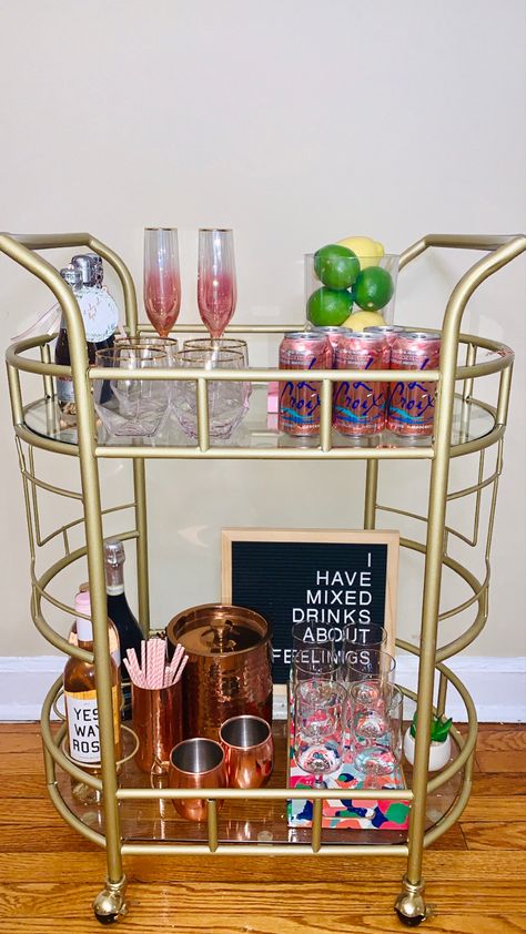 Pink Bar Cart Styling, Bev Cart Apartment, Anthropologie Apartment Decor, Bev Cart Ideas, Pink Bar Cart Aesthetic, Preppy Coffee Bar, Bar Cart Must Haves, Bar Cart Colorful, Decorated Bar Cart