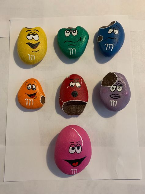 Handmade M&M Painted Rocks. Painted and detailed with acrylic paint. Paint is protected with mod podge. Type of rocks are river rocks with varying sizes but each one can fit in your hand. Painted M&m Rocks, M&m Rock Painting Ideas, Mm Rock Painting, Rock Art Ideas Easy, Rock Painting Ideas M&m, M And M Painted Rocks, M&m Painted Rocks Ideas, M And M Rock Painting, Painted Rocks M&m