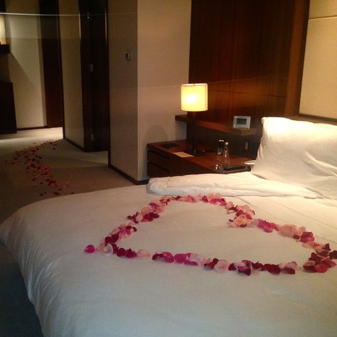 A path of rose petals, leading a trail to bed. At Langham Place, Fifth Avenue. Rose Petal On Bed Ideas, Rose Petal Bedroom Romantic, Rose Petals On Bed With Candles, Bed With Roses Petals Romantic, Rose Petals On Bed, Roses On Bed, Honeymoon Bed, Romantic Hotel Rooms, Romantic Room Decoration