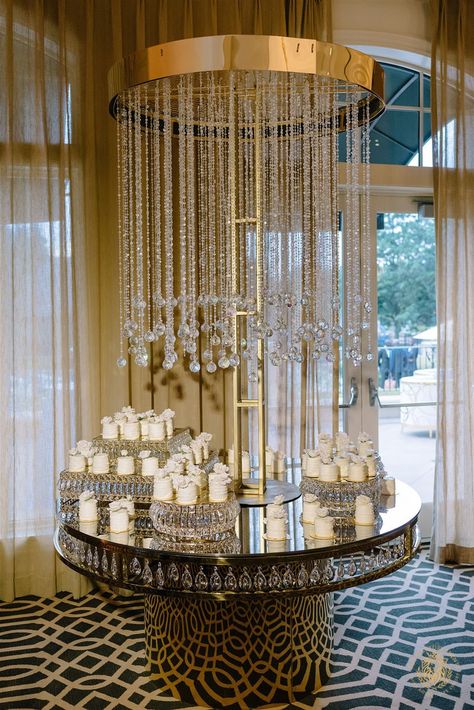 Get inspired by this romantic white and gold wedding in Houston, Texas featuring an outdoor ceremony with ivory flowers and a luxury wedding reception filled with lush floral centerpieces, white draping and luxury gold chair and table rentals. | Floral, Decor & Production: Royal Luxury Events / Photo: Khanh Nguyen Photography | wedding desserts, wedding cake display, wedding backdrops, luxury wedding, wedding reception decor, wedding inspo, wedding trends, wedding ideas, glam, mini cakes Cake Display Wedding, Luxury Event Decor, Desserts Wedding, Circle Dining Table, Table Rentals, White And Gold Wedding, Wedding Cake Display, Luxury Weddings Reception, Crystal Cake