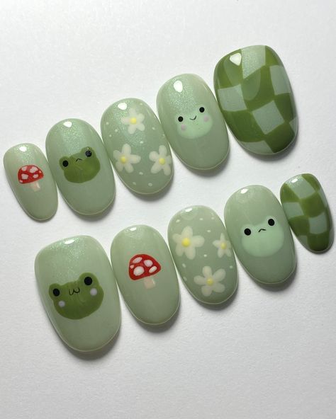 Cute little frog friends 💚 Custom Press-On Order: Tier 2 Nail Art on Extra Short Oval Nails *All press-on sets come with an application kit and instructions on how to apply and remove them Nail Art Products Used: Base color - @leafgelusa color 405 (green with glitter) Face details - @leafgelusa 001 (black) Nail art details - @mpa_onlinestore palette Top coat - @kokoistusa ultra glossy non wipe top gel Want a cute set like this one? Order a sizing kit from my shop- there are various options... Green Nails Frogs, Green Aesthetic Nails Short, Nails Design Funky, Mush Room Nails, Cute Nail Designs Animals, Short Nails Press On, Earth Themed Nails, Cute Frog Nail Designs, Cute Kawaii Nail Designs