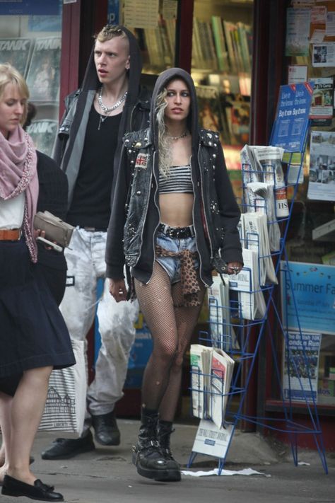 Super edgy sleaze punk fashion from Alice Dellal, wearing a cutoff leather jacket, denim shorts, ripped fishnets and grungy combat boots Ripped Fishnets, Ropa Punk Rock, Alice Dellal, Style Combat Boots, Estilo Punk Rock, Punk Style Outfits, Punk Rock Outfits, Mode Punk, 90s Fashion Grunge