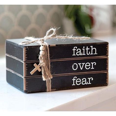 Faith Over Fear Wooden Book Stack is a religious-themed, black painted wood block with distressed edges. Stack displays the phrase, "faith over fear," in white lettering. The stack is wrapped with a jute bow and a tassel that is accented with wood beads and a cross charm. Measures 7.5" wide by 3.75" high and 5" deep. Wooden Book Decor, Dollar Tree Craft Organization Ideas, Diy Wood Books, Charm Display, Stack Displays, Wood Books, Stacked Books, Scrap Wood Crafts, Wood Block Crafts