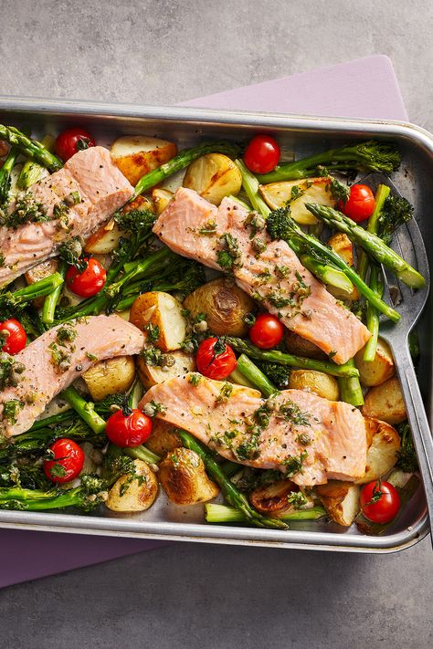 Four salmon fillets in a roasting tray on top of new potatoes, tomatoes and asparagus. Georgina Hayden, Traybake Dinner, Salmon Tray Bake, Tartiflette Recipe, Low Carb Potatoes, Lemon Pepper Salmon, Nadiya Hussain, Food Fish, Tray Bake Recipes