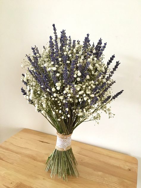 Lovely dried lavender and baby's breath wedding bouquet, tied with  hessian and lace ribbon. The lavender smells amazing and will fill you with a lovely scent all throughout your wedding day. Dried so you can keep for years to come. Bouquets come in three different sizes: Bridal bouquet 35cm H x 25cm 10" Bridesmaid 35cm H x 20cm 8" Flower girl 20 cm H x 15cm 6"   Buttonholes, flower crowns, hair combs are also available, please message me for more details.  To see more of my other buttonholes, bouquets, flower crowns, wrist corsages etc.please click here. https://www.etsy.com/uk/shop/TheFlowerworldstudio?ref=shop-header-name&listing_id=1670438210&from_page=listing If you'd like something different please drop me a message and I'll be happy to help. All my flowers are handmade so colour, si Flower Bouquet Lavender, Gypsophila Bridesmaid Bouquet, Dried Lavender Wedding, Lavender Centerpieces, Lavender Wedding Bouquet, Lavender Bridal Bouquet, Bouquet Lavender, Lavender Wedding Flowers, Flower Girl Bouquet