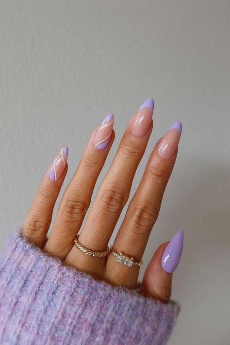 These almond-shaped nails enchant with their pastel purple tips that seamlessly blend into a sheer nude base. The subtle white line art accentuates the modern French manicure design, giving it a touch of elegance and sophistication. The overall look is soft, feminine, and effortlessly chic.  // Photo Credit: Instagram @vivianmariewong Pastel Purple French Tip Nails Almond, Almond Shaped Nail Designs Summer, Lavanda Nails Designs, Elegant Nails Pastel, Oval Nails Lavender, Almond Nails Designs Lavender, Chic Almond Nail Designs, French Tip Nails With Design Purple, Nude And Lavender Nails