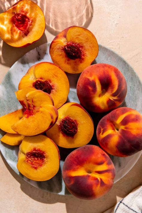 Fresh peaches cut in half and sliced. Peach Food Photography, Tn Aesthetic, Peaches Photography, Peaches Aesthetic, Bowl Of Peaches, Peach Leaves, Almond Crumble, Calendar Planning, Peach Decor