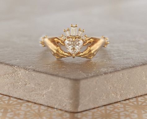 This exquisite Claddagh ring features a sparkling Moissanite heart (approx. 0.5ct), cradled by a crown of baguette diamonds (total carat weight approx. 0.55ct).  Made in your choice of 10K, 14K, or 18K Rose, Yellow, or White gold, or Platinum.  The classic design symbolizes love, friendship, and loyalty, making it a timeless heirloom.  Customize your heart stone!  Please allow 2-3 weeks for production. Sizes up to 8 included, contact us for larger sizes. Friendship Hands, Irish Promise Rings, Wedding Ring Heart, Claddagh Wedding Ring, Women Alternative, Fiance Ring, Irish Ring, Claddagh Ring Wedding, Skull Wedding Ring