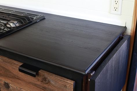 Considering adding black kitchen countertops to your home? Come see how we updated butcher block countertops for a rustic modern vibe in our RV. MountainModernLife.com #rvrenovation #rvremodel #rvkitchen #blackcounters #blackcountertops #rusticmodern #rusticmodernkitchen #mountainmodern #diycounters #tinykitchen #tinyhome #camperremodel #mountainmodernlife Black Stain Butcher Block Countertops, Ebony Stained Butcher Block Countertops, Black Stained Butcher Block Countertops, Van Countertops, Ebony Butcher Block Countertops, Black Wood Countertops, Gray Stained Butcher Block Countertops, Dark Butcher Block Countertops Kitchen, Black Butcher Block Countertops